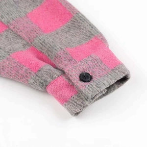 Detail of pink and grey plaid shirt cuff with soft flannel texture and black button