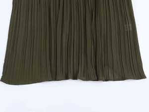 Detailed view of deep olive green pleated midi dress hemline in lightweight chiffon fabric