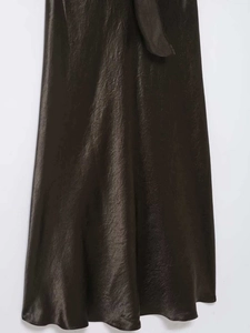 Detailed view of dark brown satin midi skirt with silky texture and elegant waist tie