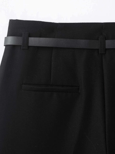 Detail einer schwarzen 7/8-Hose mit weitem Bein, inklusive schmalem Gürtel und Paspeltaschen