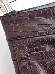 Vue détaillée du simili cuir marron foncé avec texture crocodile et coutures précises