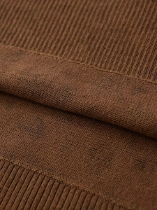 Close-up of the caramel brown ribbed knit texture and soft fabric stitching details