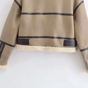 Detail der khakifarbenen Wildlederjacke mit schwarzen Lederstreifen und weißem Fleecefutter