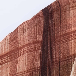 Detailed close-up showing the brown plaid fabric texture of the elegant high-waist dress