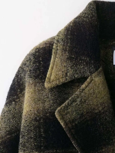 Close-up of retro plaid wool coat fabric with textured yellow and black check pattern