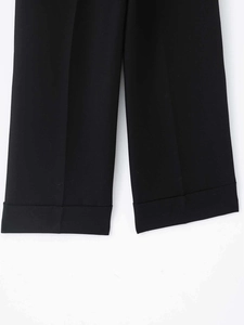 Detailaufnahme der umgeschlagenen Saumkante an einer schwarzen weiten Hose mit feiner Naht
