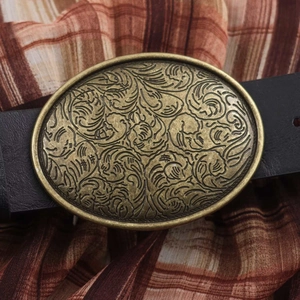Elegant vintage oval bronze belt buckle with floral relief on black leather waist belt