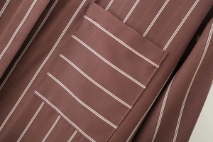 Dettaglio della tasca di camicia a righe marroni con trama del tessuto e cuciture pulite