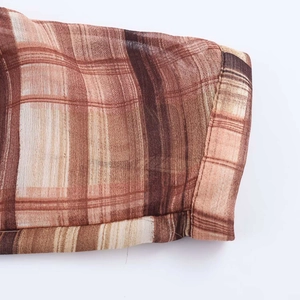 Detail shot of the vintage plaid fabric texture and neat stitching on summer dress edges
