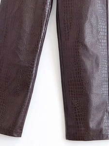 Détail du pantalon en cuir PU marron foncé avec gaufrage crocodile et texture riche