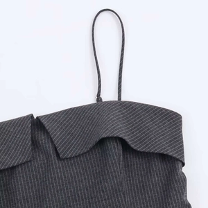 Dettaglio del vestito gessato grigio con scollatura a pieghe e spalline sottili a spaghetti