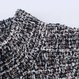 Macro shot of high-quality grey tweed fabric texture with woven black and brown fibers