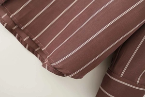 Dettaglio del tessuto della camicia a righe marroni con cuciture fini e linee bianche