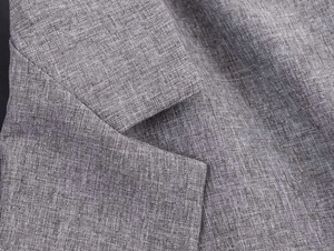 Close-up detail of grey herringbone blazer lapel showing high-quality linen texture