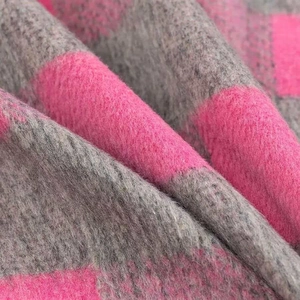 Close-up of thick checkered flannel fabric in fuchsia and dark grey with fuzzy texture