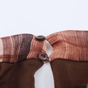 Detail view of brown plaid mesh fabric and two round buttons on a summer dress