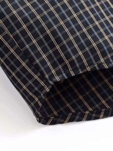 Gros plan détaillé sur la texture du tissu à carreaux foncés et les coutures précises