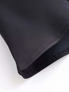 Detailed close-up showing the precise stitching and smooth satin texture of the black shirt