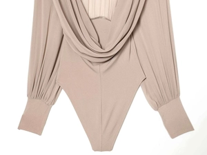 Close-up of elegant apricot pleated sleeves and draped back detail on bodysuit
