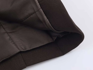Dettaglio del tessuto twill marrone cioccolato con fodera in raso liscio della giacca