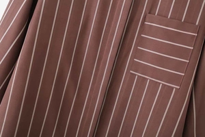 Dettaglio del tessuto della camicia a righe marroni e cucitura della tasca sul petto
