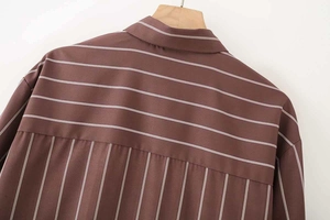 Dettaglio della camicia a righe marroni che mostra motivi a righe orizzontali e verticali