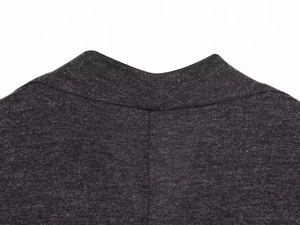 Détail d'un pull en maille gris foncé à col montant montrant la texture du tissu