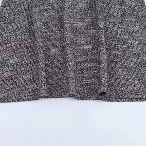 Close-up of grey textured tweed fabric hem with professional stitching and woven pattern
