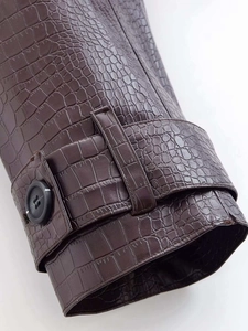 Gros plan sur le poignet en cuir marron à motif crocodile avec sangle de serrage