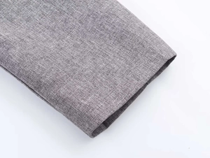 Detailed close-up of melange grey woven fabric texture and neat stitching on sleeve hem