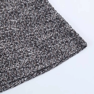 Detailed macro view of the grey tweed fabric texture and hem on a sleeveless dress