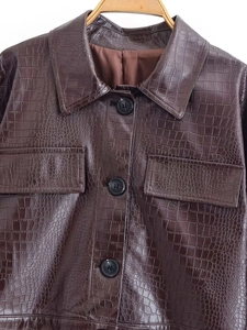 Gros plan sur une veste en cuir marron foncé à motif crocodile avec col et poches
