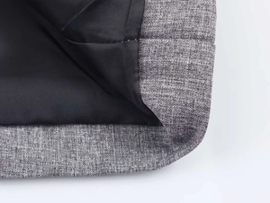 Detail view of herringbone blazer fabric texture with neat black lining and sewing