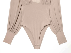 Detailed close-up of nude long-sleeve bodysuit featuring pleated chiffon sleeves and cuffs