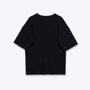 Détail du haut en maille noir oversize présentant une couture verticale au dos unique