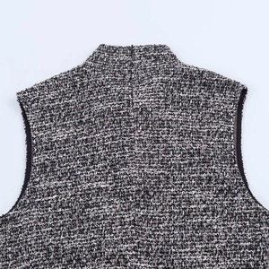 Detail of grey textured sleeveless dress featuring back zipper and tweed fabric weave