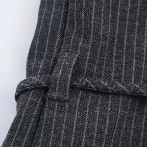 Dettaglio del tessuto a righe grigio scuro con sottile cintura abbinata in vita