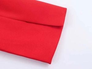 Detailed close-up of vibrant red blazer fabric showing premium weave texture and stitching