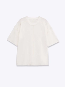 Détail d'un haut en tricot blanc à manches courtes avec col rond et couture centrale