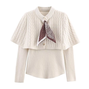 Dettaglio del set in maglia bianco crema con coprispalle a trecce e foulard in seta paisley