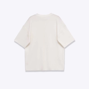 Détail de la couture verticale et de l'épaule sur un haut en maille blanc cassé à manches