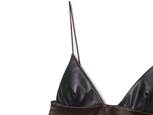 Détail du patchwork en cuir PU noir et satin marron foncé sur le caraco pour femmes