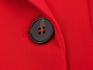 Macro shot of dark marbled buttons and fine weave texture on a red double-breasted blazer