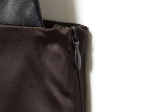 Détail de couture asymétrique avec tissu marron foncé et fermeture éclair invisible noire