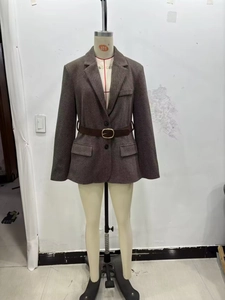 Détail d'un blazer marron à chevrons avec ceinture en cuir et boucle dorée ovale