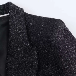 Detailed macro view of black tweed fabric with metallic silver threads and texture