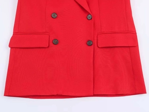 Close-up of red double-breasted blazer showing textured woven fabric and button detail