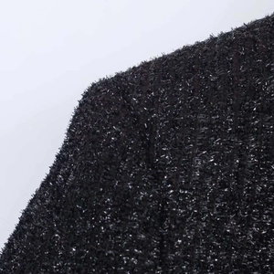 Close-up of black fuzzy fabric featuring silver metallic threads and textured finish