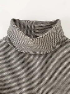 Detailed close-up of high neck collar and classic houndstooth pattern texture