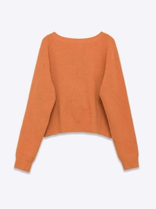 Close-up of caramel orange knit sweater showing thick texture and ribbed cuffs